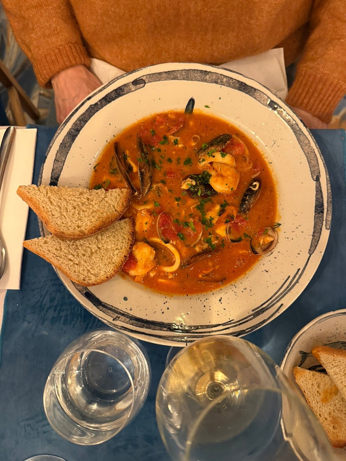 Supă de fructe de mare în sos roșu, cu midii și pâine prăjită